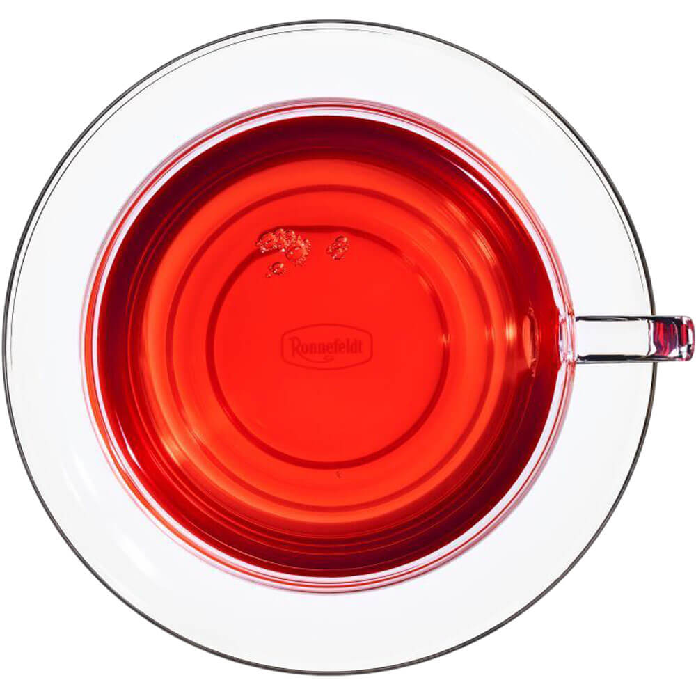 Leuchtend roter Ronnefeldt Cosy Apple bio Früchtetee in Glastasse von oben fotografiert