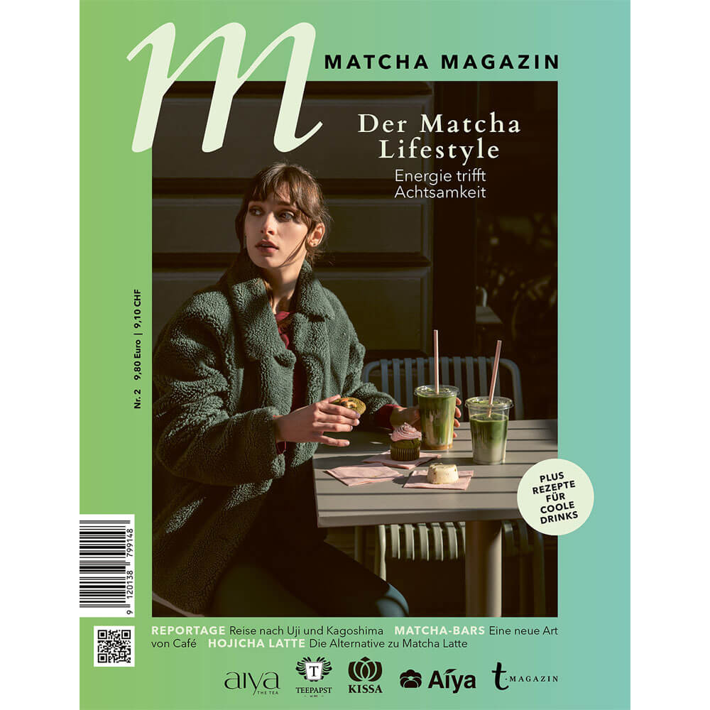 Cover des Matcha Magazin: junge Frau im grünen Mantel sitzt im Café an einem Tisch mit zwei Matcha-Getränken und Gebäck, Titel „Der Matcha Lifestyle – Energie trifft Achtsamkeit“, moderne grün-türkise Gestaltung.#magazin_matcha-magazin-2